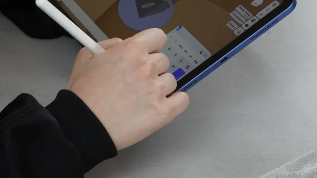 Close-up of a hand editing a CAD design on a tablet with a stylus